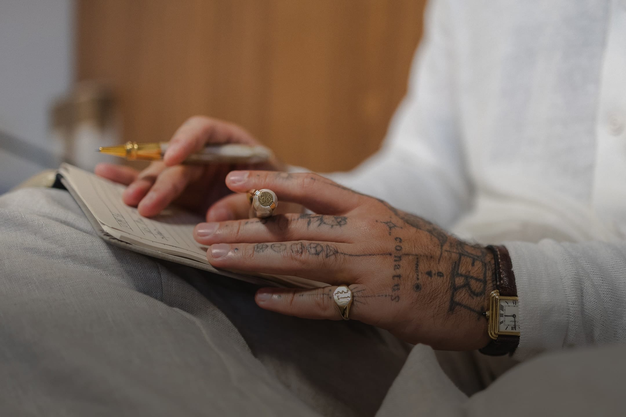 Mãos do Dr. Eric Pascher escrevendo com caneta-tinteiro sobre um caderno